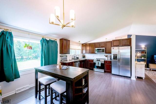 11812 Fox River Rd, Twin Lakes, WI 53181 - kitchen with appliances with stainless steel finishes, a chandelier, dark wood finished floors, healthy amount of natural light, and lofted ceiling
