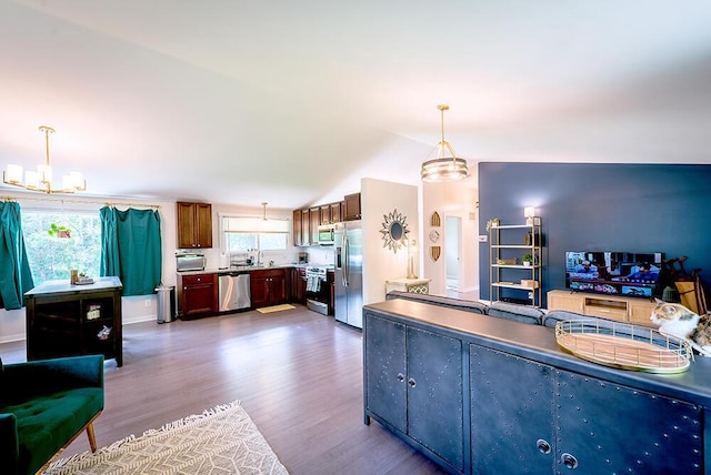 11812 Fox River Rd, Twin Lakes, WI 53181 - kitchen with appliances with stainless steel finishes, wood finished floors, hanging light fixtures, open floor plan, and a chandelier