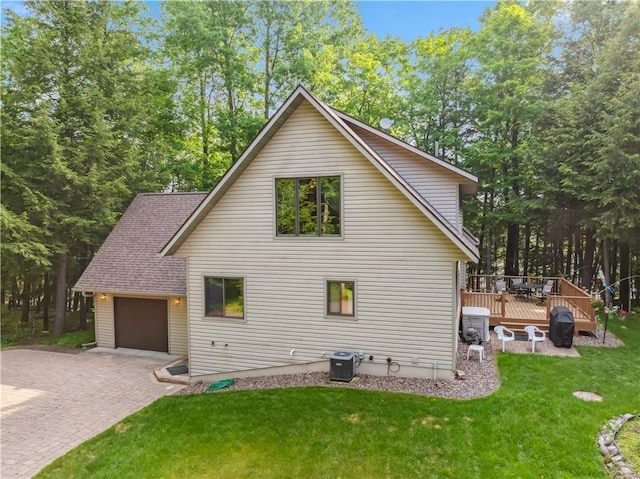 9926 W Birch Circle Dr, Ladysmith, WI 54848 - view of side of property featuring decorative driveway, an attached garage, a lawn, a wooden deck, and roof with shingles