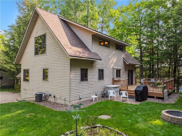 9926 W Birch Circle Dr, Ladysmith, WI 54848 - rear view of property with a shingled roof, a fire pit, a lawn, and a wooden deck