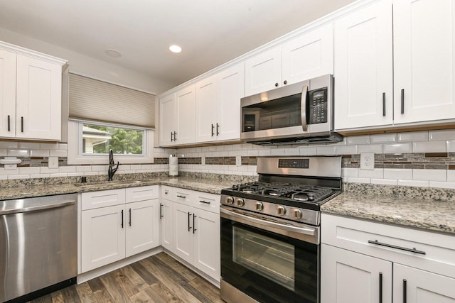 6913 Butternut Rd, Racine, WI 53402 - kitchen featuring stainless steel appliances, backsplash, white cabinets, dark wood-style floors, and light stone countertops