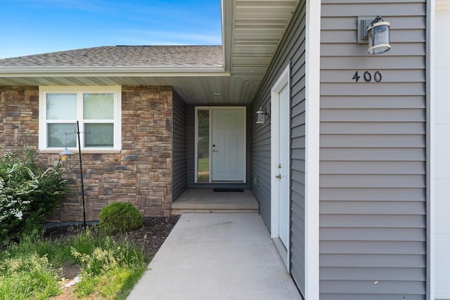 400 Tristan Dr, Shawano, WI 54166 - doorway to property featuring stone siding and roof with shingles