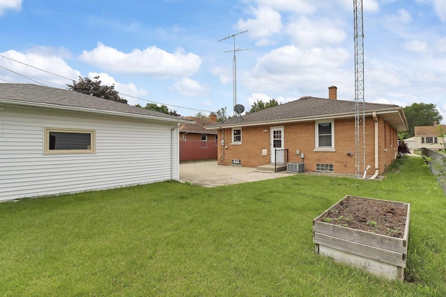 7631 38th Ave, Kenosha, WI 53142 - rear view of house with a patio area, a vegetable garden, a lawn, a chimney, and brick siding