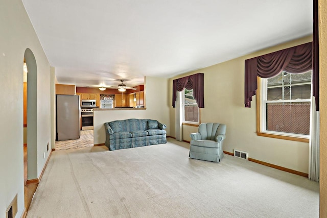 7631 38th Ave, Kenosha, WI 53142 - living area with arched walkways, light colored carpet, and a ceiling fan