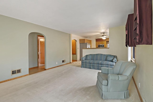 7631 38th Ave, Kenosha, WI 53142 - living area featuring arched walkways, ceiling fan, and light colored carpet