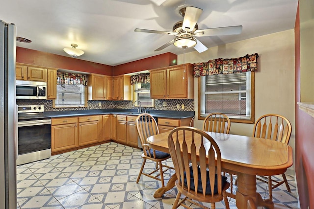 7631 38th Ave, Kenosha, WI 53142 - kitchen featuring stainless steel appliances, tasteful backsplash, dark countertops, and a ceiling fan