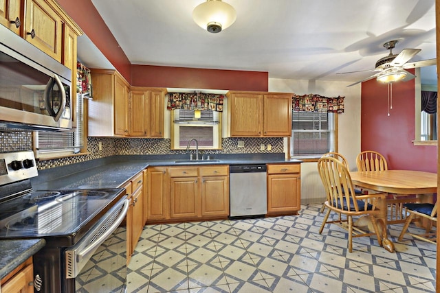 7631 38th Ave, Kenosha, WI 53142 - kitchen featuring appliances with stainless steel finishes, light flooring, dark countertops, and backsplash