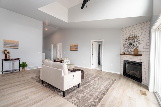 922 Vogt Ln, Chilton, WI 53014 - living area with vaulted ceiling, light wood-style floors, a ceiling fan, and a large fireplace