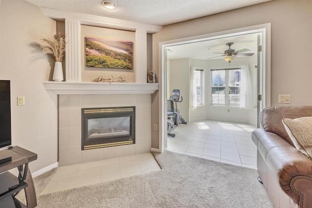8530 Greenway Blvd Unit 104, Middleton, WI 53562 - carpeted living area featuring a tiled fireplace, tile patterned flooring, a ceiling fan, and a textured ceiling