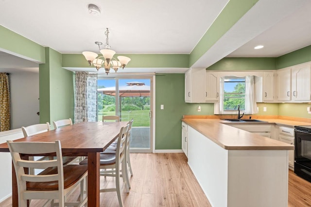 W330S7517 Split Rail Dr, Mukwonago, WI 53149 - kitchen featuring a chandelier, white cabinetry, a peninsula, light wood-style floors, and recessed lighting