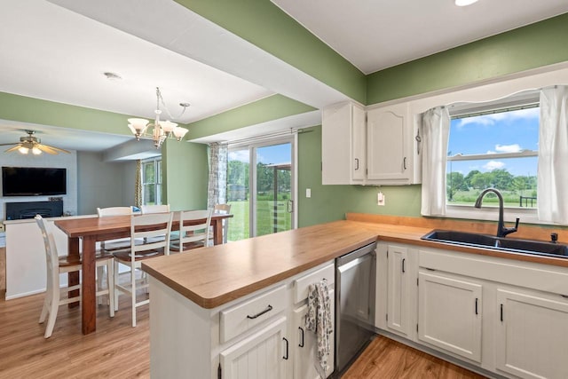 W330S7517 Split Rail Dr, Mukwonago, WI 53149 - kitchen featuring stainless steel dishwasher, white cabinetry, light wood finished floors, a peninsula, and a chandelier