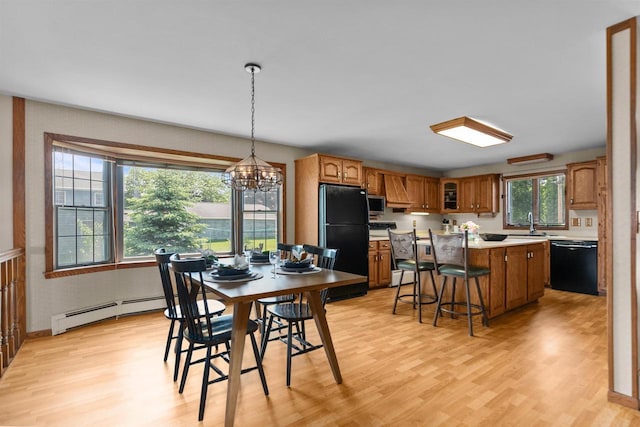 6352 Black Wolf Point Ln, Oshkosh, WI 54902 - dining area featuring a baseboard radiator, light wood-style flooring, and a chandelier