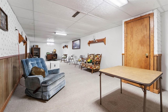 38 Bowen St, Oshkosh, WI 54901 - living area with carpet flooring, a paneled ceiling, wood walls, and a wainscoted wall