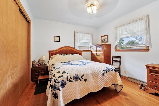 38 Bowen St, Oshkosh, WI 54901 - bedroom with baseboard heating, a closet, light wood-type flooring, and ceiling fan