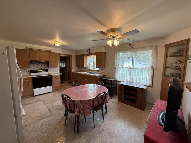 317 Reed St, Chilton, WI 53014 - kitchen with white appliances, under cabinet range hood, light countertops, ceiling fan, and brown cabinetry