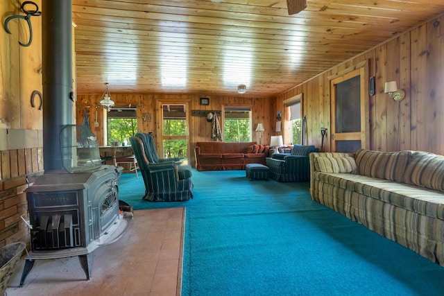 N14066 Squaw Creek Rd, Wausaukee, WI 54177 - carpeted living room featuring a wood stove, wooden walls, and wood ceiling