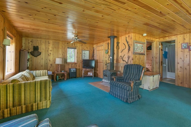 N14066 Squaw Creek Rd, Wausaukee, WI 54177 - living area with wooden walls, a wood stove, carpet flooring, wooden ceiling, and ceiling fan