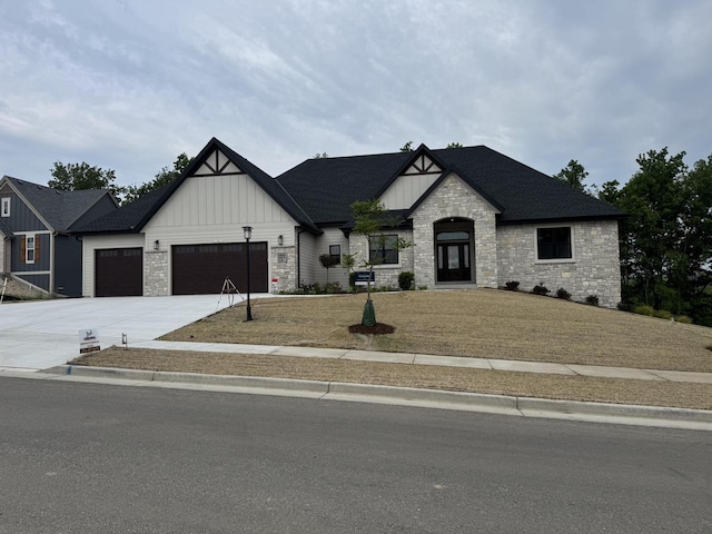 213 W Fairview Dr, Menomonee Falls, WI 53051 - view of front of house with stone siding, board and batten siding, an attached garage, concrete driveway, and a front lawn