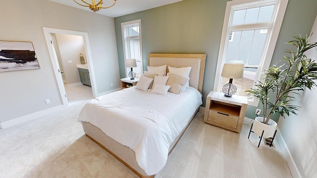213 W Fairview Dr, Menomonee Falls, WI 53051 - bedroom featuring light carpet, ensuite bathroom, and a chandelier