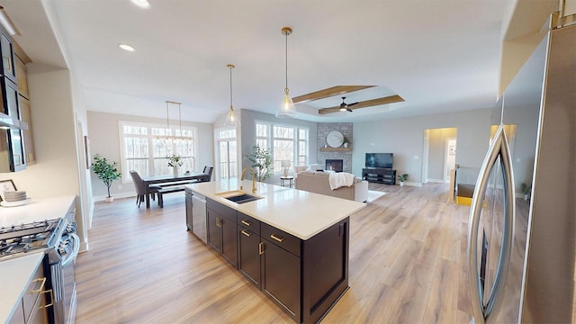 213 W Fairview Dr, Menomonee Falls, WI 53051 - kitchen with appliances with stainless steel finishes, a ceiling fan, a fireplace, light wood-style flooring, and recessed lighting