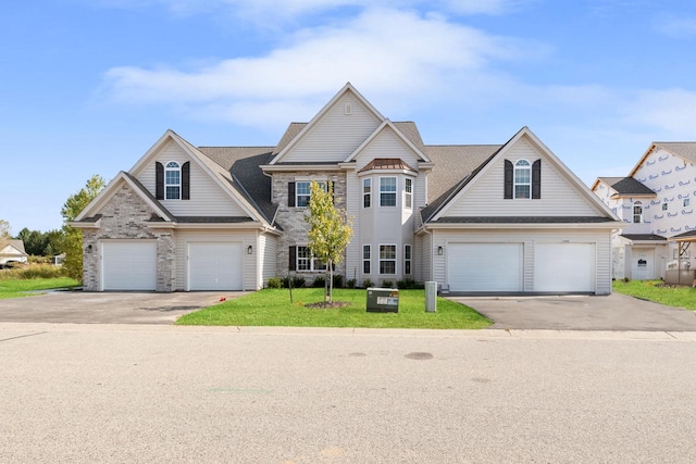1887 Woodland Way, Slinger, WI 53086 - traditional-style house featuring driveway, an attached garage, a front yard, and stone siding