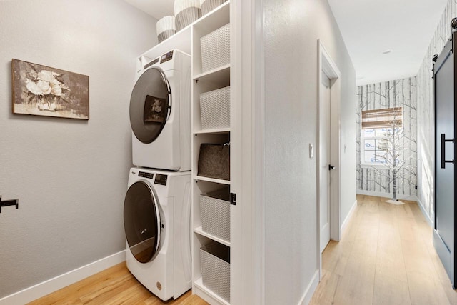 1887 Woodland Way, Slinger, WI 53086 - laundry area featuring stacked washer and clothes dryer, light wood-style flooring, and a barn door