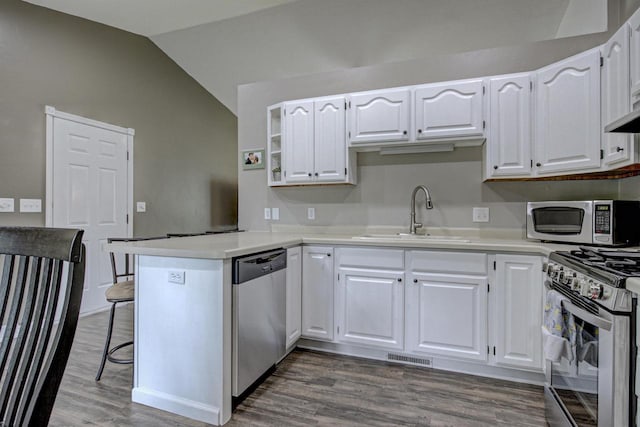 324 Nancy Ln, Pulaski, WI 54162 - kitchen featuring stainless steel appliances, a peninsula, lofted ceiling, white cabinetry, and wood finished floors