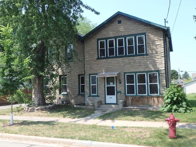 328 2nd St, Menasha, WI 54952 - view of front facade featuring stone siding and a front lawn