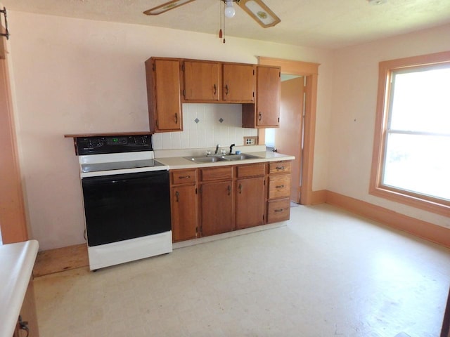 328 2nd St, Menasha, WI 54952 - kitchen featuring range with electric cooktop, brown cabinetry, light countertops, ceiling fan, and backsplash