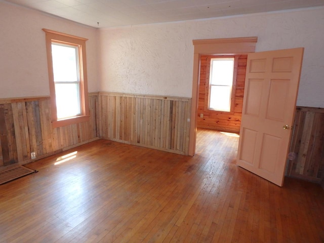328 2nd St, Menasha, WI 54952 - unfurnished room featuring a wainscoted wall, wood-type flooring, wooden walls, and healthy amount of natural light