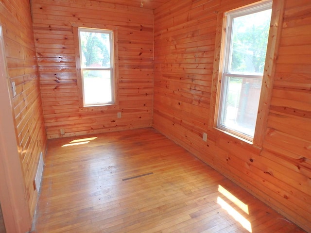 328 2nd St, Menasha, WI 54952 - empty room featuring light wood finished floors, wood walls, and plenty of natural light