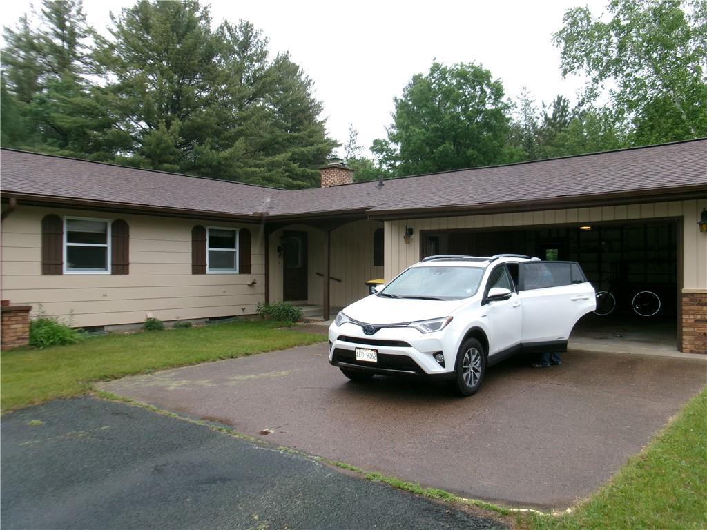10564 Hamblin St, Hayward, WI 54843 - ranch-style house with driveway, an attached garage, a chimney, and a shingled roof