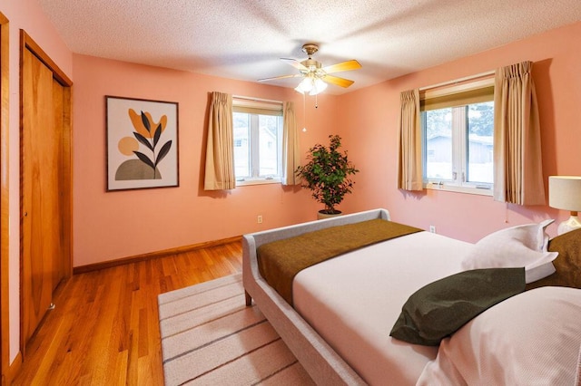 3424 Geneva Ln, La Crosse, WI 54601 - bedroom featuring light wood-style floors, a textured ceiling, and a ceiling fan