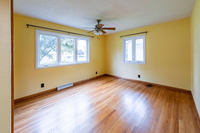 3424 Geneva Ln, La Crosse, WI 54601 - spare room featuring plenty of natural light, light wood-type flooring, a ceiling fan, and a textured ceiling