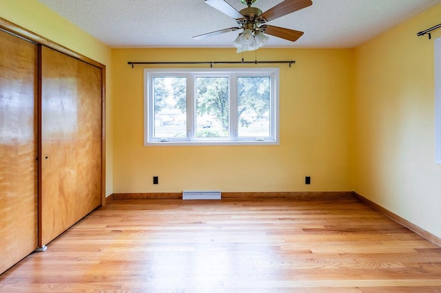 3424 Geneva Ln, La Crosse, WI 54601 - unfurnished bedroom featuring light wood-style floors, a closet, a textured ceiling, and a ceiling fan