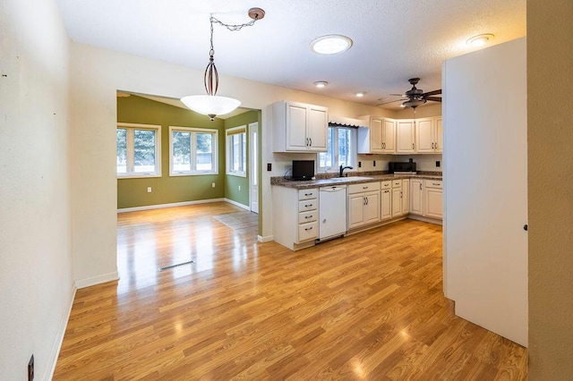 3424 Geneva Ln, La Crosse, WI 54601 - kitchen with white dishwasher, light wood-style flooring, ceiling fan, pendant lighting, and white cabinetry