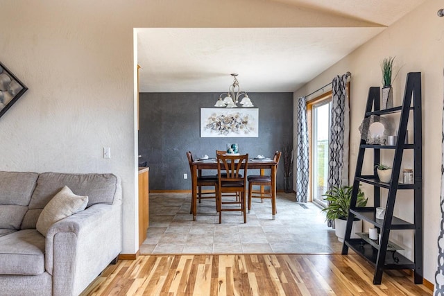217 Lemongrass Way, Kaukauna, WI 54130 - dining space with a chandelier, light wood-type flooring, an accent wall, and lofted ceiling