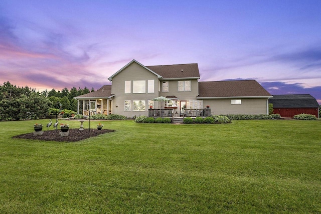 5685 Blake Rd, De Pere, WI 54115 - back of house at dusk featuring a lawn and a deck