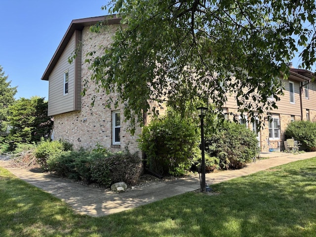 501 Hartridge Dr, Hartland, WI 53029 - view of home's exterior with brick siding and a lawn