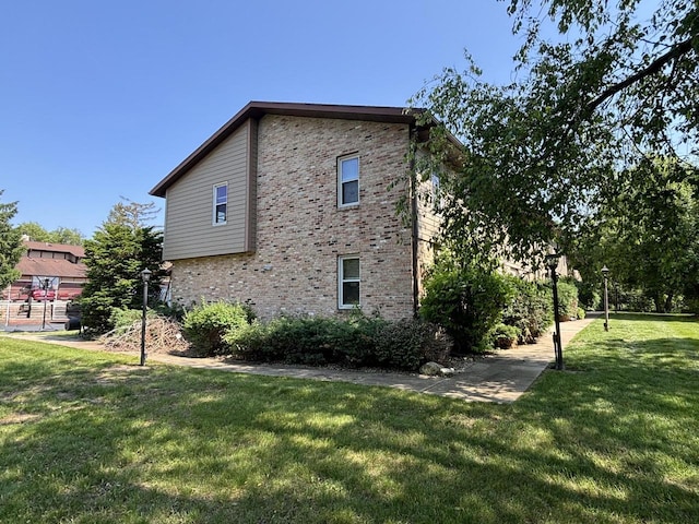 501 Hartridge Dr, Hartland, WI 53029 - view of side of home featuring a yard and brick siding