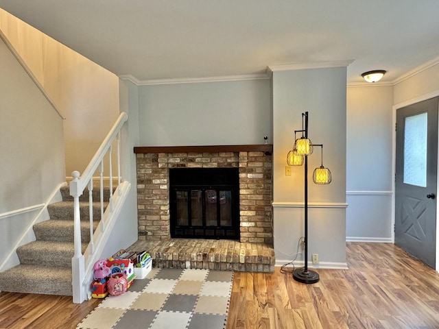 501 Hartridge Dr, Hartland, WI 53029 - living room featuring wood finished floors, stairs, crown molding, and a fireplace