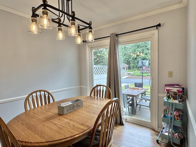 501 Hartridge Dr, Hartland, WI 53029 - dining area featuring light wood-type flooring, ornamental molding, and a chandelier