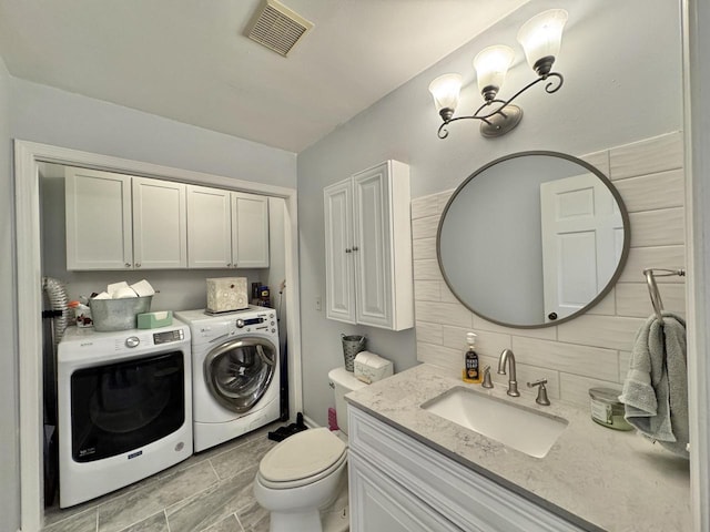 501 Hartridge Dr, Hartland, WI 53029 - bathroom with washer and dryer, decorative backsplash, and vanity