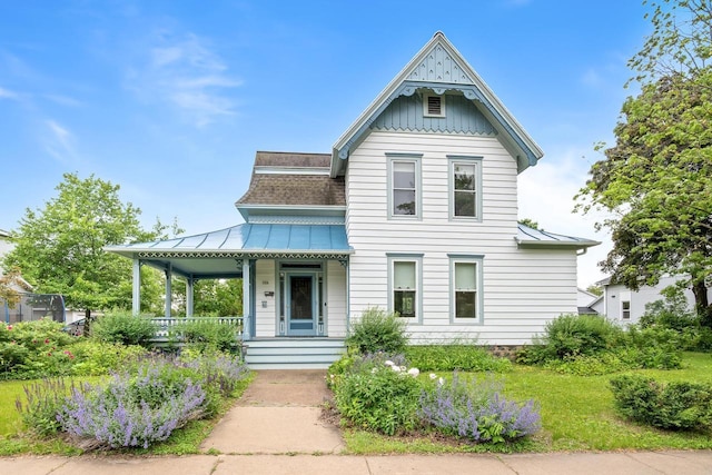 204 E Huron St, Berlin, WI 54923 - victorian-style house featuring a standing seam roof, covered porch, board and batten siding, a metal roof, and a shingled roof