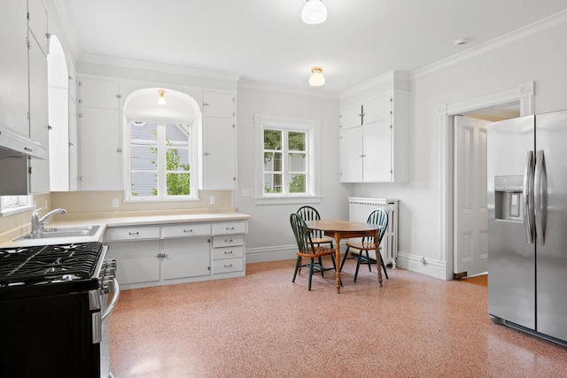 204 E Huron St, Berlin, WI 54923 - kitchen with appliances with stainless steel finishes, radiator heating unit, white cabinets, ornamental molding, and light countertops