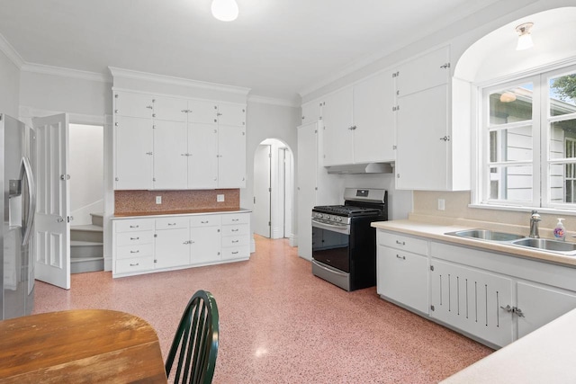204 E Huron St, Berlin, WI 54923 - kitchen with appliances with stainless steel finishes, range hood, crown molding, white cabinetry, and arched walkways