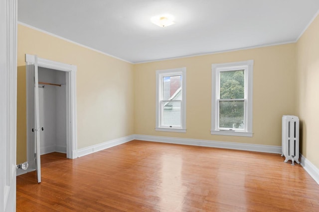 204 E Huron St, Berlin, WI 54923 - unfurnished bedroom featuring radiator, light wood finished floors, and crown molding