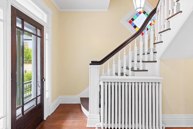 204 E Huron St, Berlin, WI 54923 - entryway featuring radiator, wood finished floors, ornamental molding, and stairway