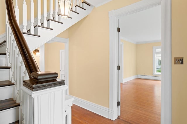 204 E Huron St, Berlin, WI 54923 - staircase featuring baseboard heating, wood finished floors, and crown molding