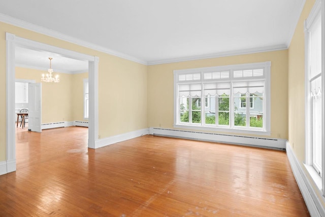 204 E Huron St, Berlin, WI 54923 - spare room with baseboard heating, a chandelier, wood finished floors, and ornamental molding